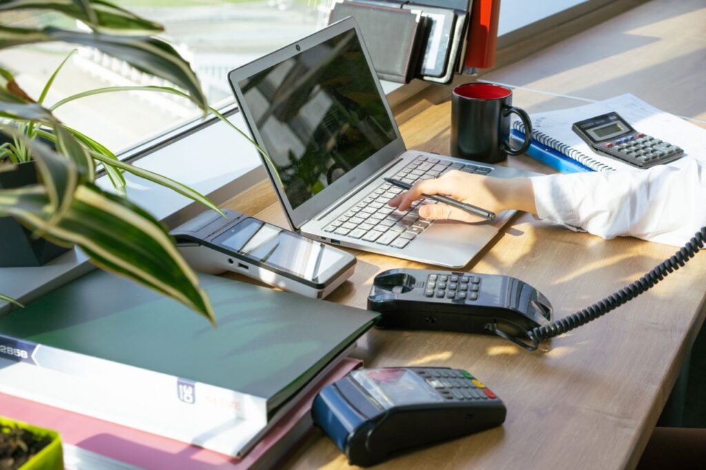 A bright modern office desk setup with electronic devices and plants, ideal for productivity.