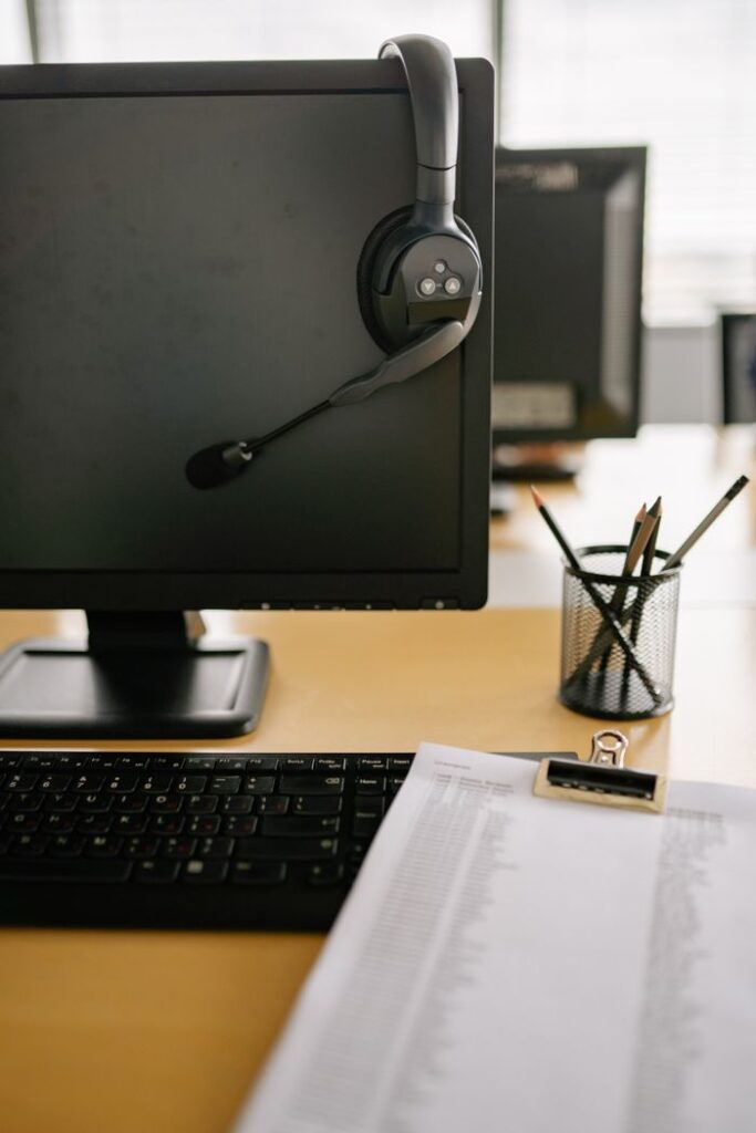 Clean and organized workspace featuring a computer monitor with headset in a modern office setting.